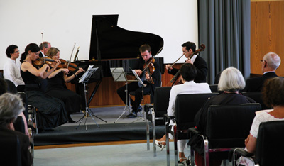 V plenárním sále budovy akademie se v zahajovací den symposia konal též komorní koncert z děl Antonína Dvořáka, Jana Kubelíka a Josefa Suka.