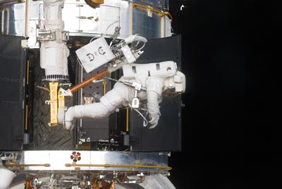 Astronaut Andrew Feustel na podnožce na konci robotického manipulátoru raketoplánu Atlantis.